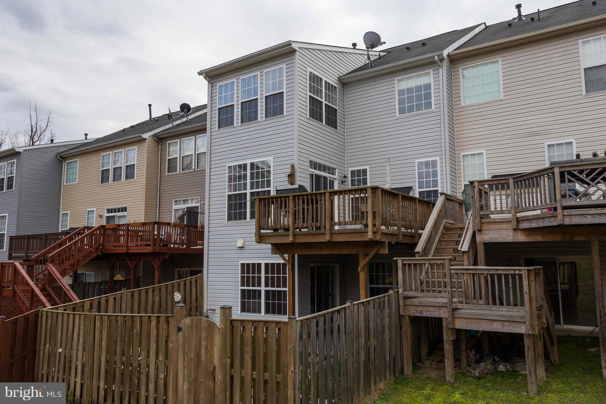 2242 Henry Watts Loop Woodbridge, VA 22191 - Photo 30 of 30 a view of a house with wooden deck and furniture