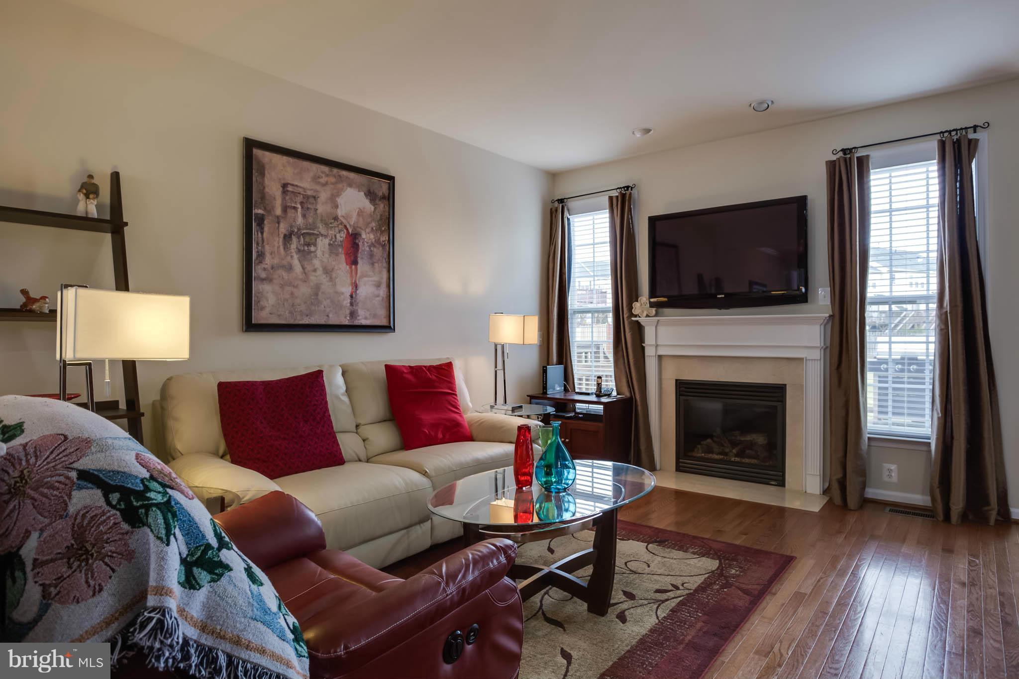 2242 Henry Watts Loop Woodbridge, VA 22191 - Photo 8 of 30 a living room with furniture a flat screen tv and a fireplace