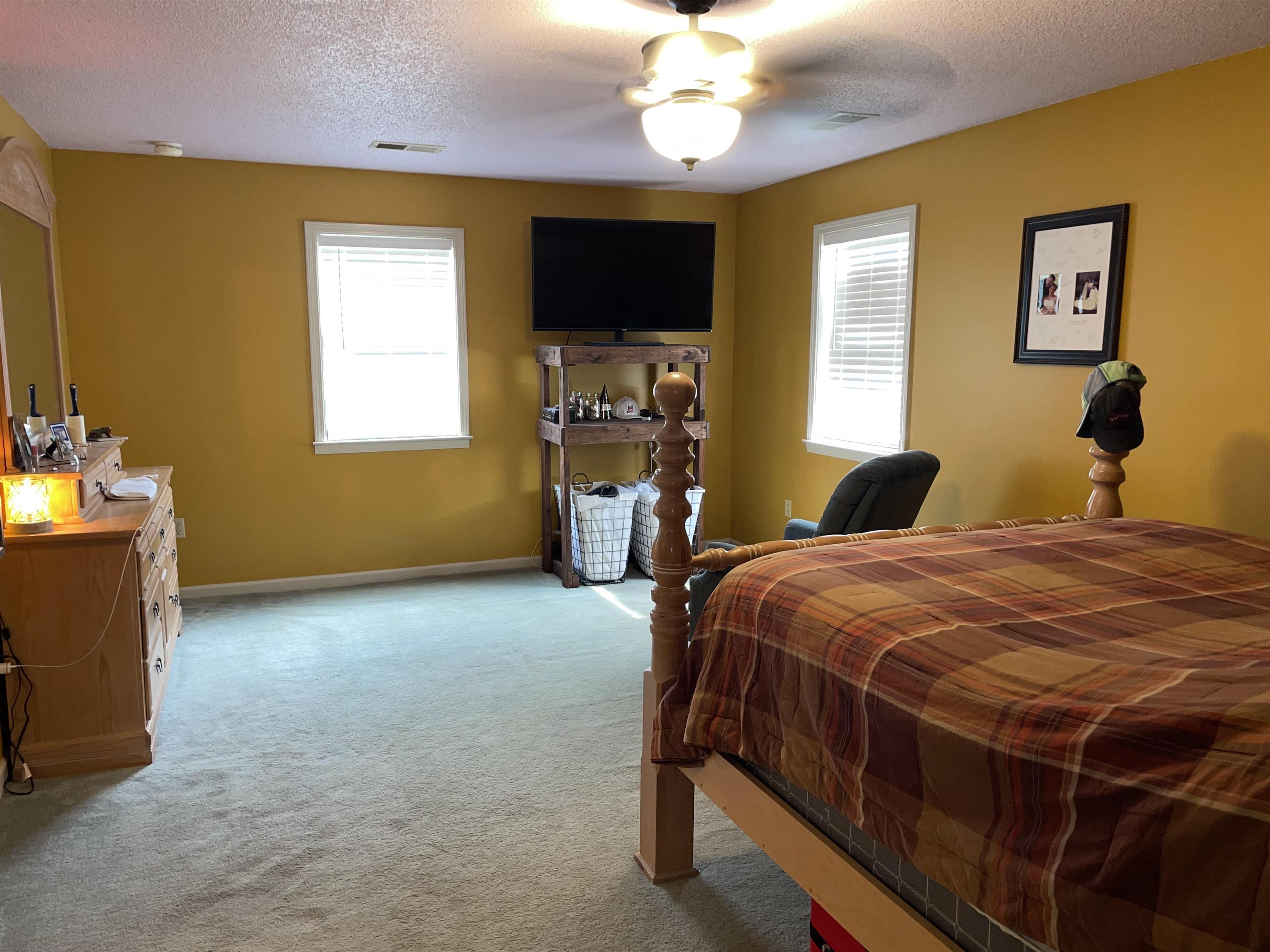 2879 Randolph Road Burlison, TN 38015 - Photo 16 of 29 Bedroom featuring ceiling fan, a textured ceiling, and light carpet