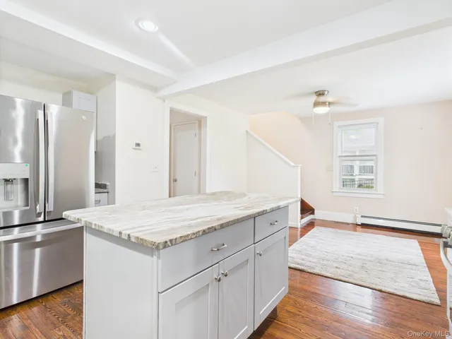 a hall with kitchen island white cabinets and sink