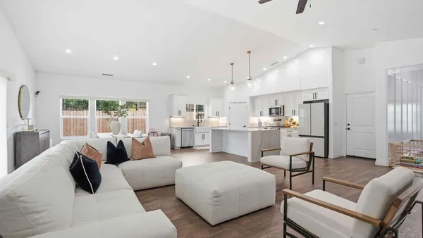 a large kitchen with stainless steel appliances a large counter top a stove a sink a dining table and chairs