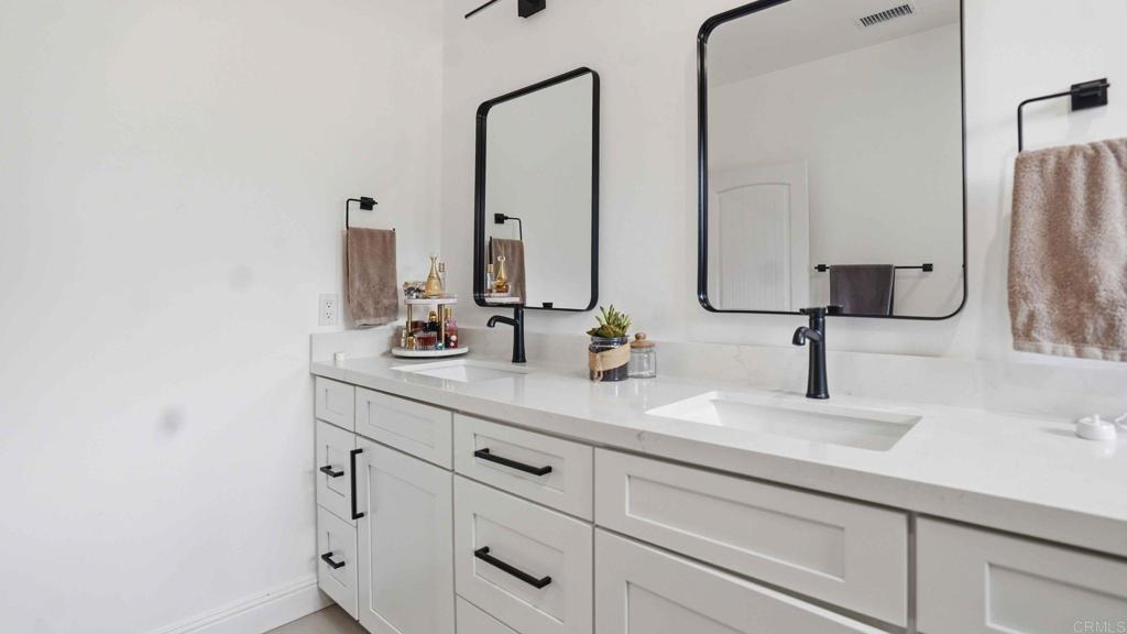 9391 Los Coches Road Lakeside, CA 92040 - Photo 33 of 65 a bathroom with double vanity sinks and a mirror