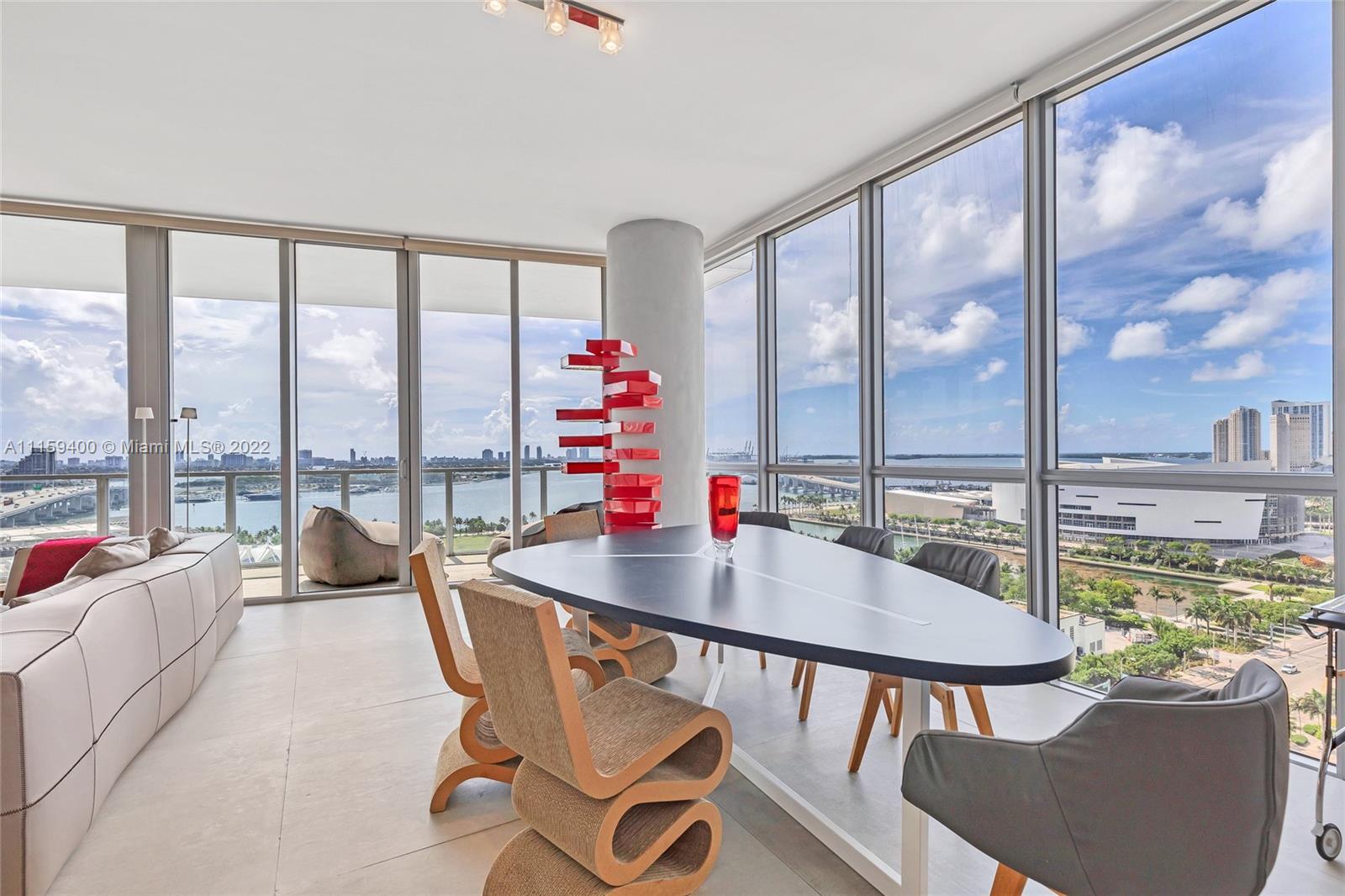 1100 Biscayne Boulevard, Unit 1801 Miami, FL 33132 - Photo 12 of 27 a dining room with furniture a chandelier and wooden floor