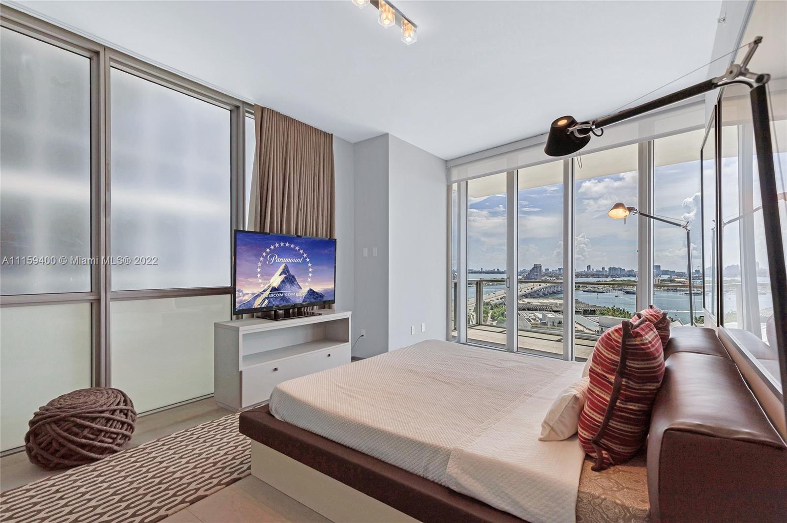 1100 Biscayne Boulevard, Unit 1801 Miami, FL 33132 - Photo 16 of 27 a bedroom with a bed and a large window