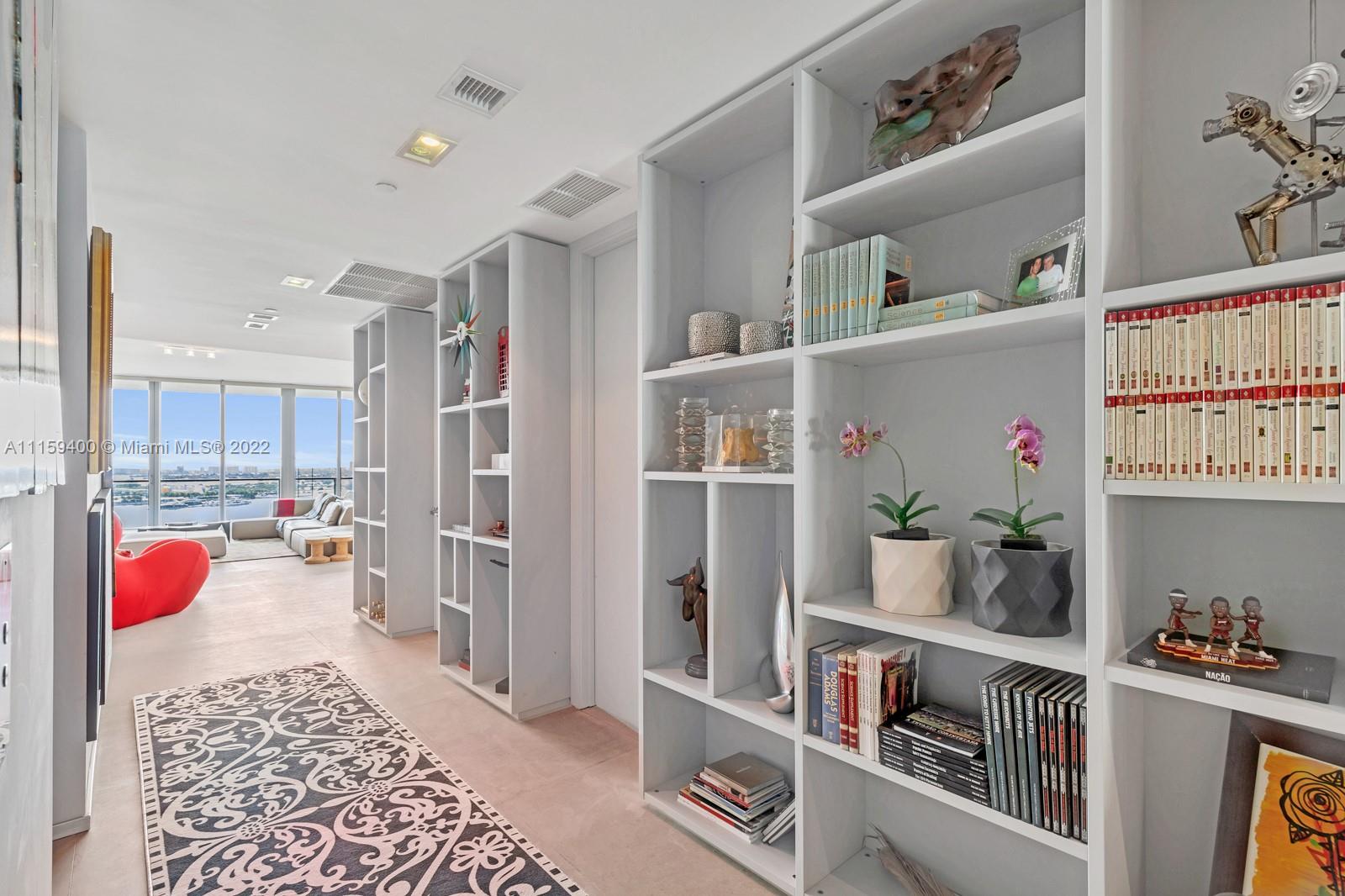 1100 Biscayne Boulevard, Unit 1801 Miami, FL 33132 - Photo 3 of 27 a living room with furniture and a book shelf