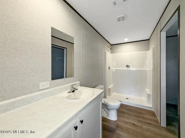 a bathroom with a granite countertop sink a toilet and shower