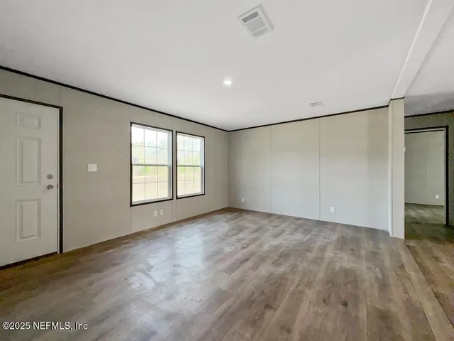 an empty room with windows and closet