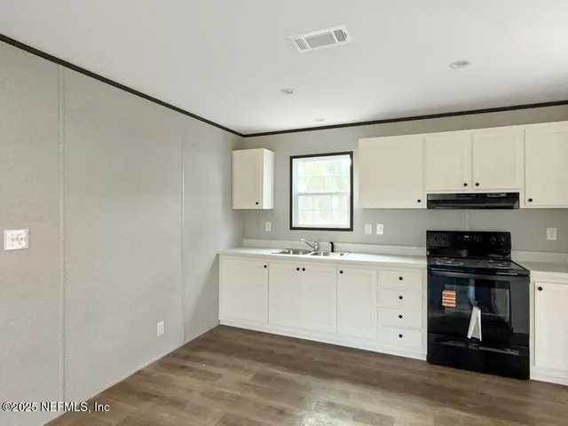 a view of a kitchen with sink cabinets and wooden floor