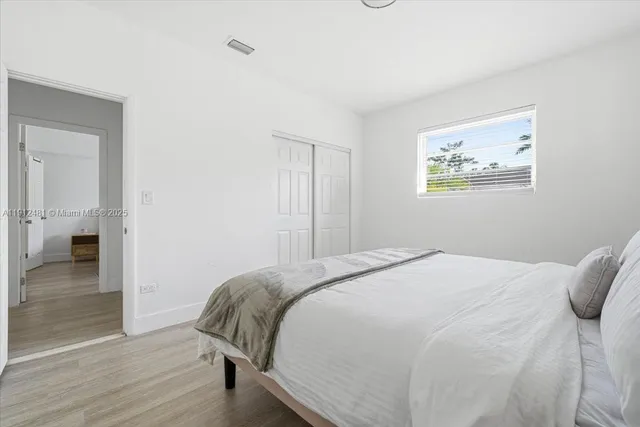 a bedroom with a bed and wooden floor