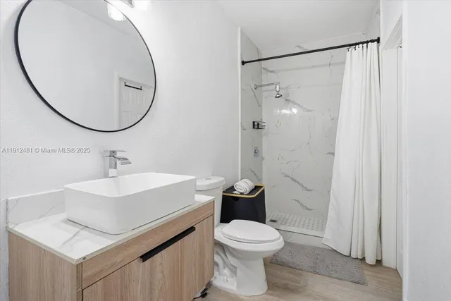 a bathroom with a sink toilet and a mirror