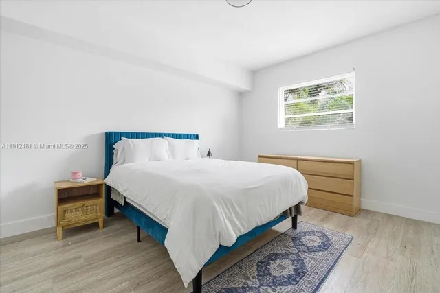 a bedroom with a bed and a night stand