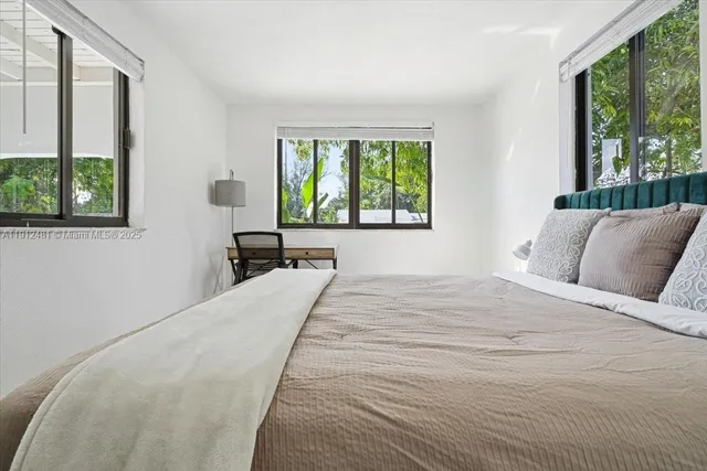 a bedroom with a large bed and a large window