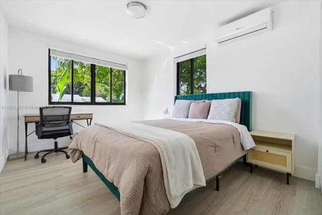 a bedroom with a bed a mirror and a window