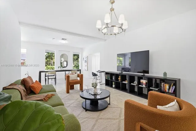 a living room with furniture and a chandelier