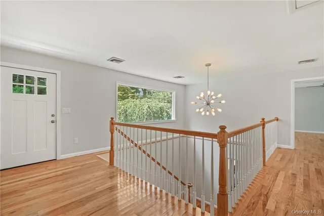 a view of a hallway with wooden floor and stairs