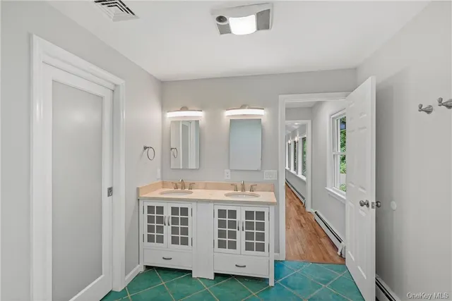 a spacious bathroom with a double vanity sink and a mirror