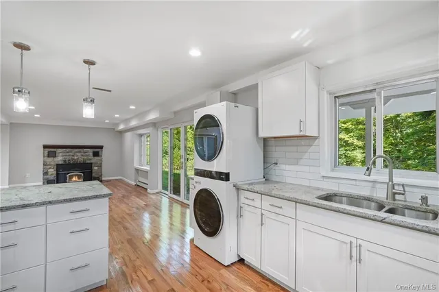 a kitchen with kitchen island granite countertop a sink a stove and cabinets