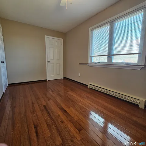 a view of a room with wooden floor and window