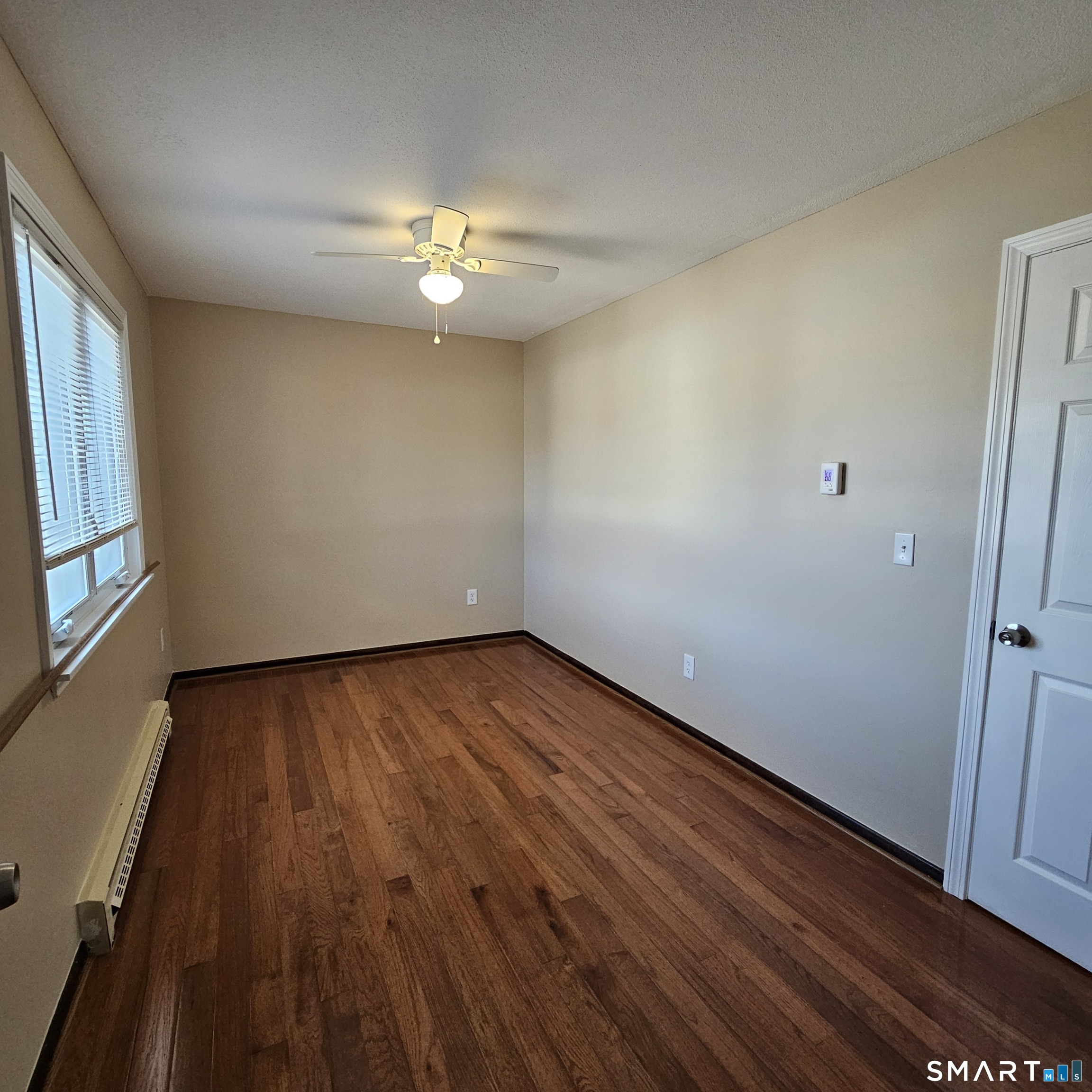 373 Wolcott Street Bristol, CT 06010 - Photo 7 of 23 an empty room with wooden floor and windows