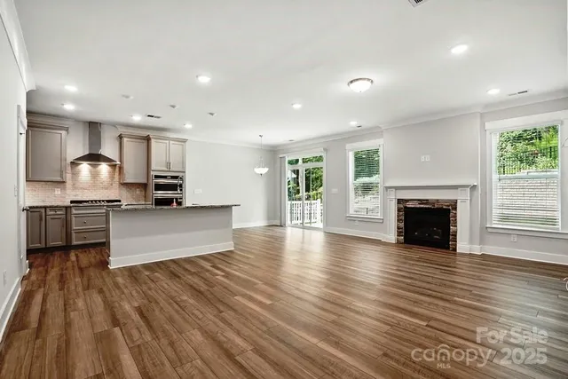 a view of kitchen with cabinets stainless steel appliances and wooden floor