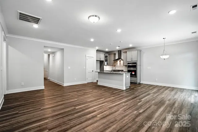 a view of kitchen with kitchen island wooden floor center island and stainless steel appliances