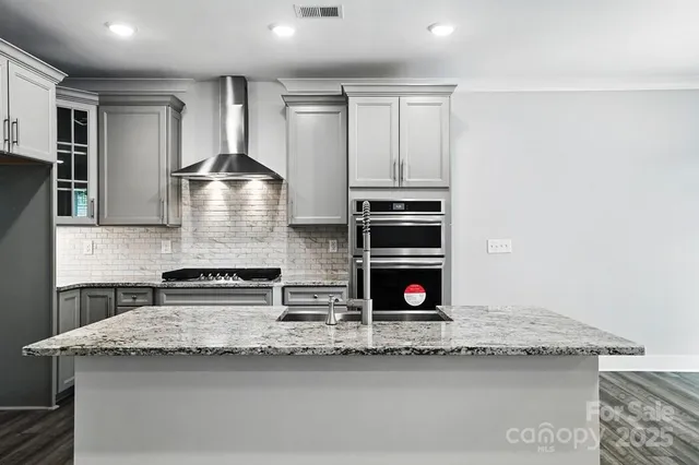 a kitchen with stainless steel appliances granite countertop a stove and a sink