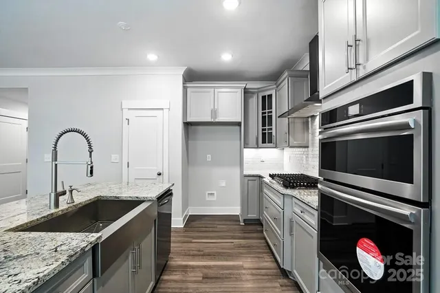 a kitchen with stainless steel appliances granite countertop a sink and a stove