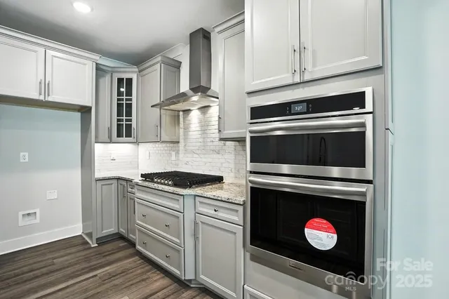 a kitchen with stainless steel appliances granite countertop a stove microwave and cabinets