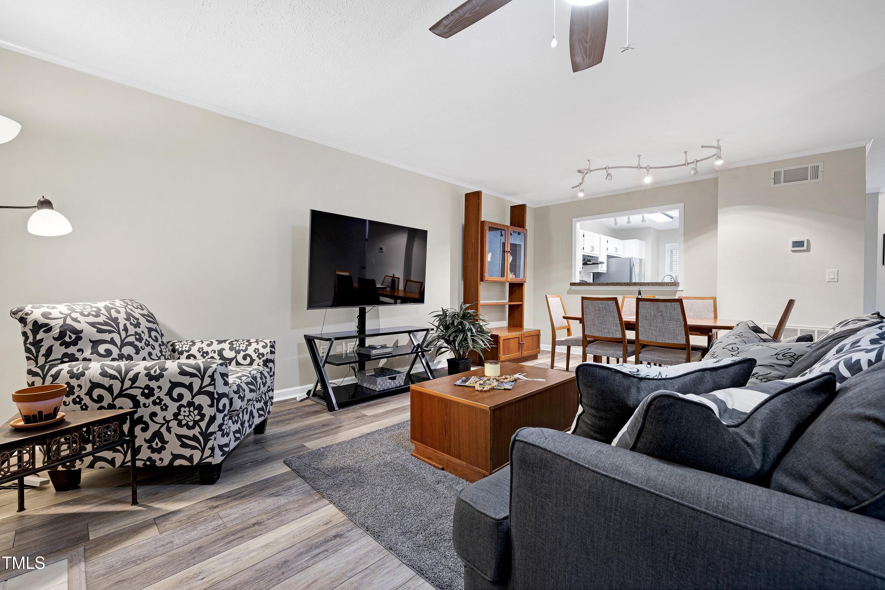 202 Oak Hollow Court Raleigh, NC 27613 - Photo 11 of 44 a living room with furniture a flat screen tv and kitchen view