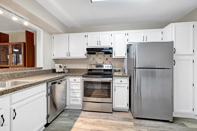 a kitchen with cabinets stainless steel appliances and a counter space