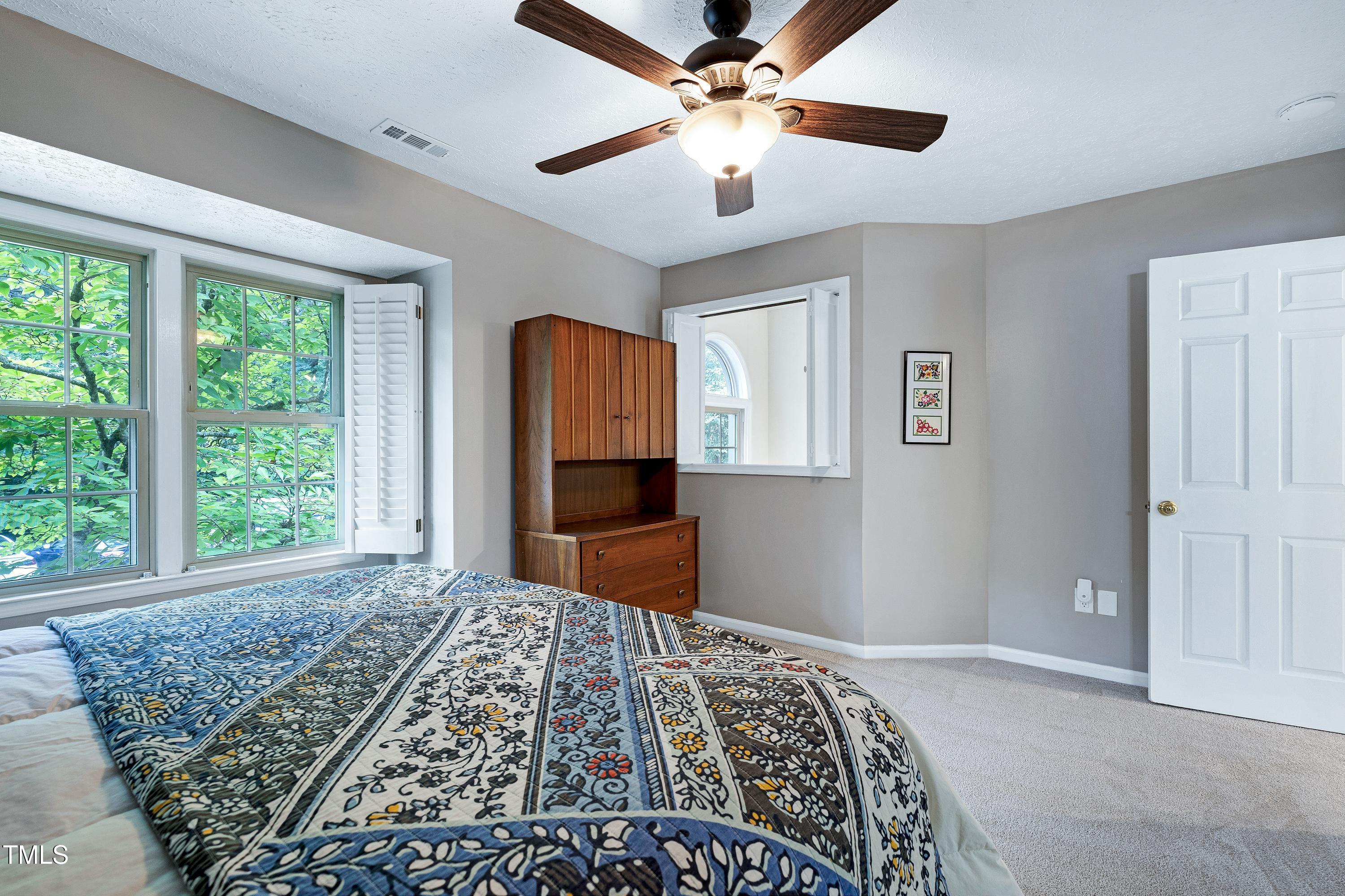 202 Oak Hollow Court Raleigh, NC 27613 - Photo 21 of 44 a bedroom with a large bed and a chandelier