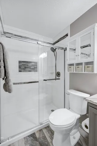 a bedroom with a large bed and a chandelier fan