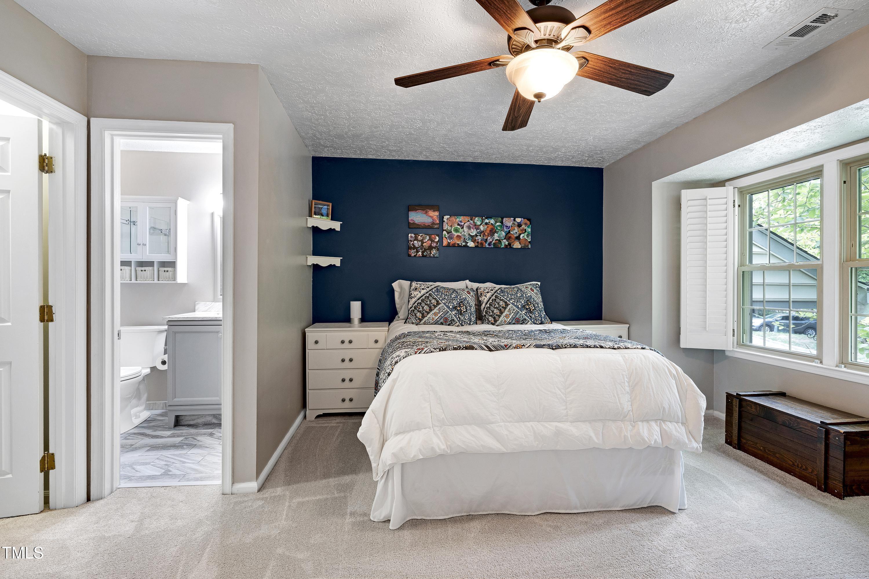 202 Oak Hollow Court Raleigh, NC 27613 - Photo 24 of 44 a bedroom with a large bed and a chandelier fan