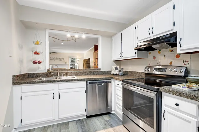 a kitchen with granite countertop wooden cabinets and a stove