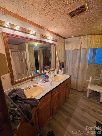 a bathroom with a double vanity sink toilet and shower