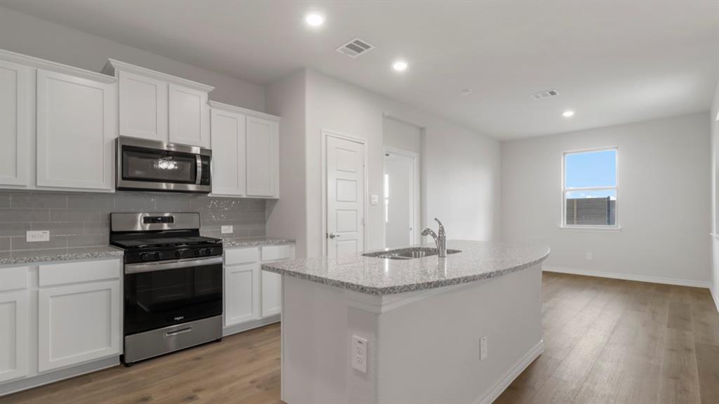 510 Range Road Caddo Mills, TX 75135 - Photo 17 of 25 a kitchen with stainless steel appliances granite countertop a stove a sink and a microwave
