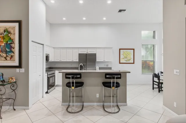 a large living room with stainless steel appliances kitchen island granite countertop furniture and a flat screen tv