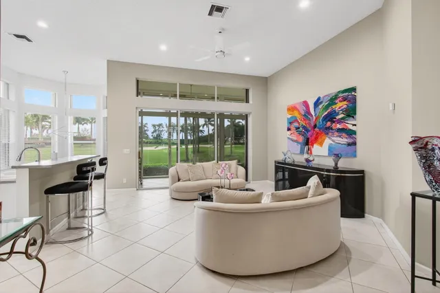 a living room with furniture and floor to ceiling windows