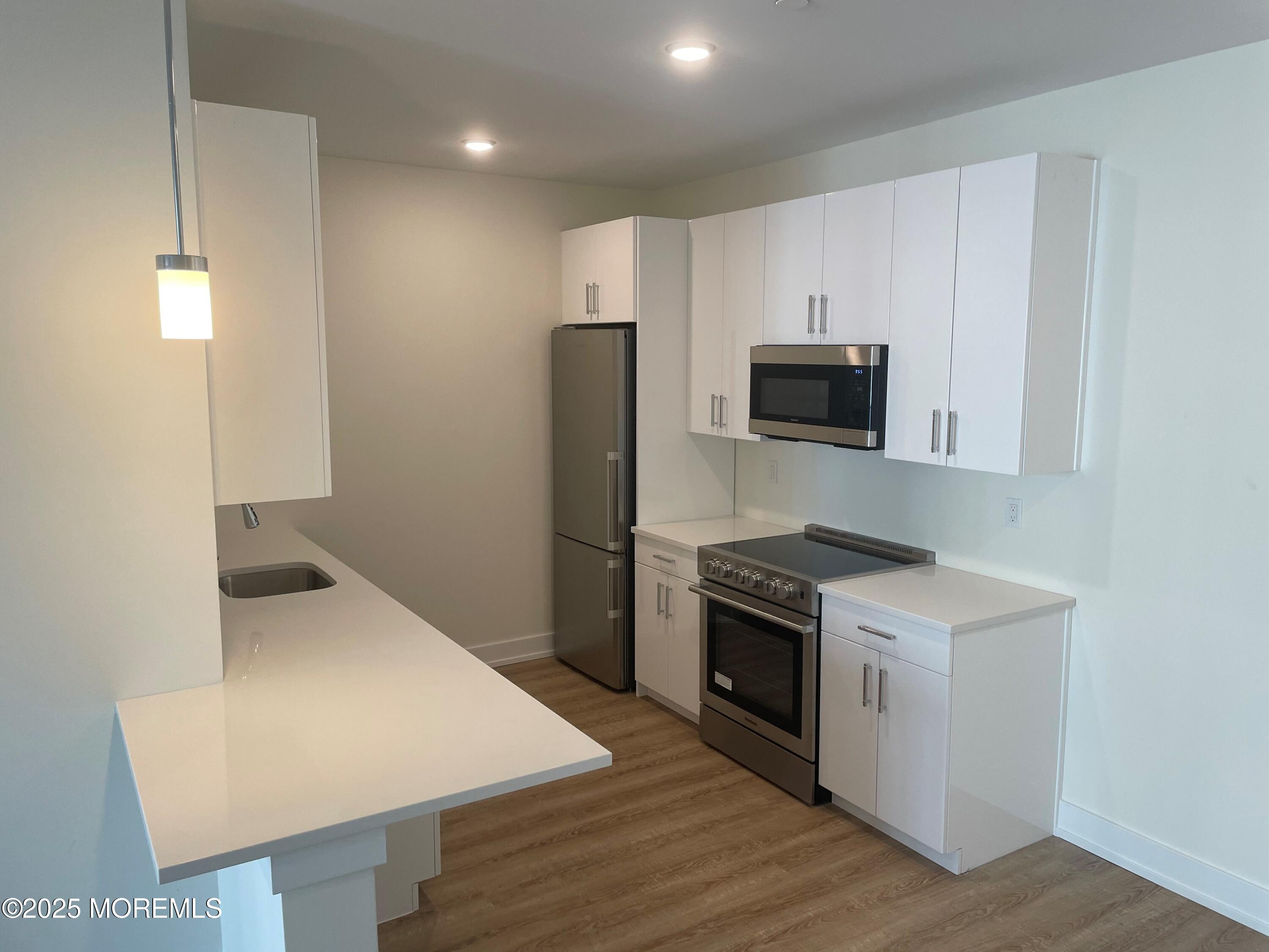 521 Lake Avenue, Unit 408 Asbury Park, NJ 07712 - Photo 2 of 30 a kitchen with a stove a refrigerator and a sink