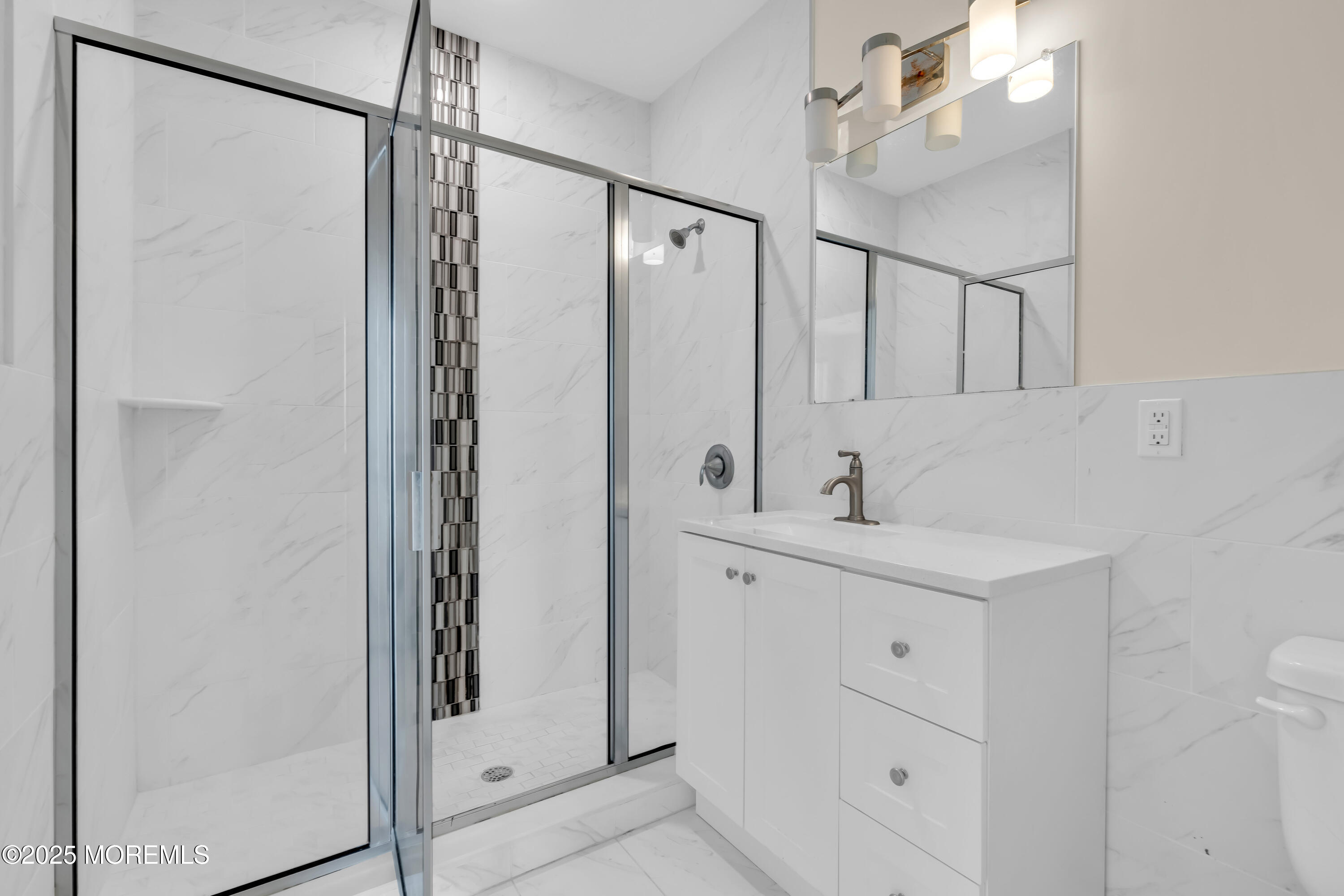 521 Lake Avenue, Unit 408 Asbury Park, NJ 07712 - Photo 22 of 30 a bathroom with a shower sink and mirror