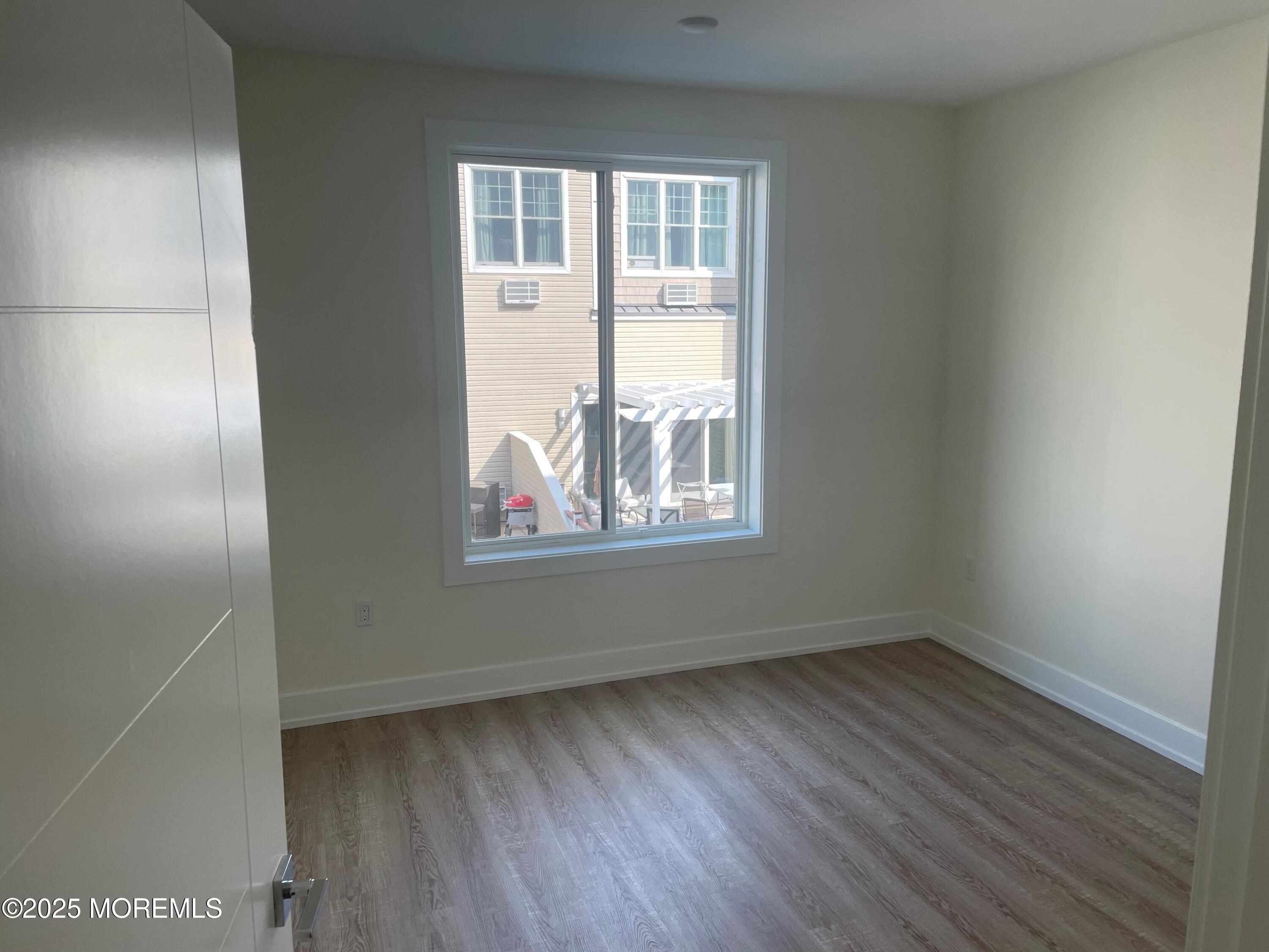 521 Lake Avenue, Unit 408 Asbury Park, NJ 07712 - Photo 4 of 30 an empty room with wooden floor and windows