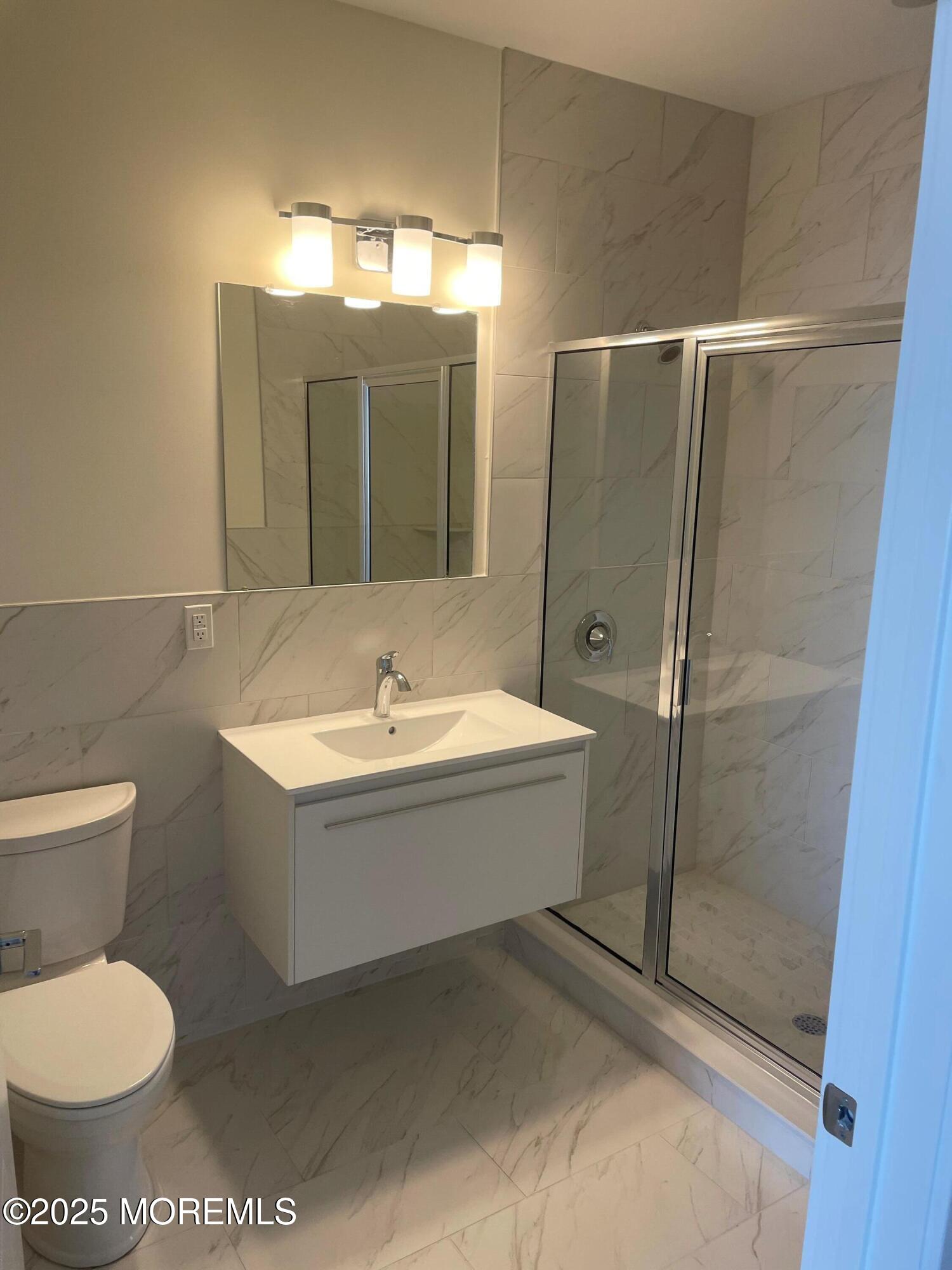 521 Lake Avenue, Unit 408 Asbury Park, NJ 07712 - Photo 6 of 30 a bathroom with a toilet sink and mirror