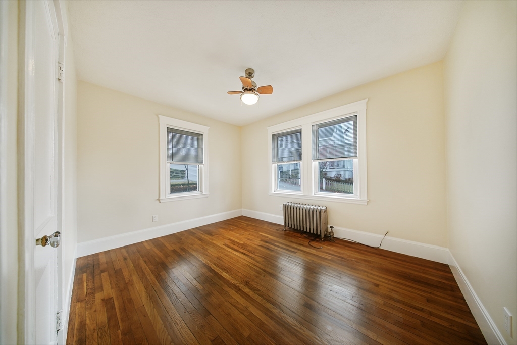 39 McDonald Street, Unit 39 Quincy, MA 02169 - Photo 11 of 15 an empty room with wooden floor and windows