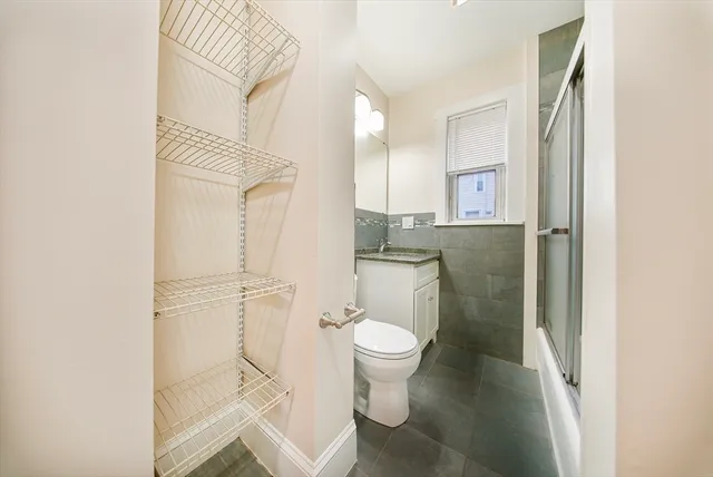 a bathroom with a granite countertop toilet sink and a mirror