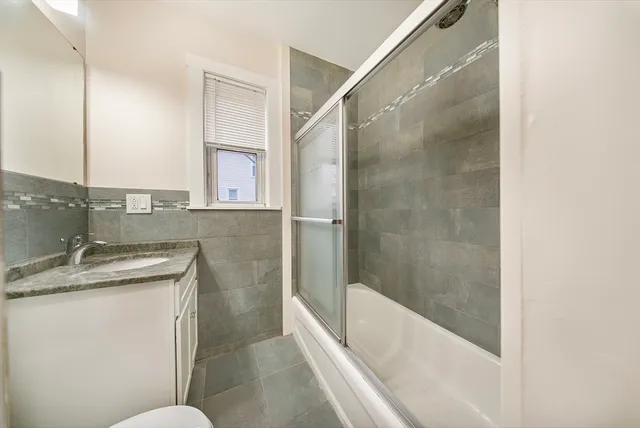a bathroom with a granite countertop sink a toilet and bathtub