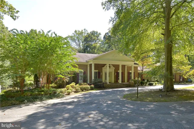 a front view of a house with a yard and trees