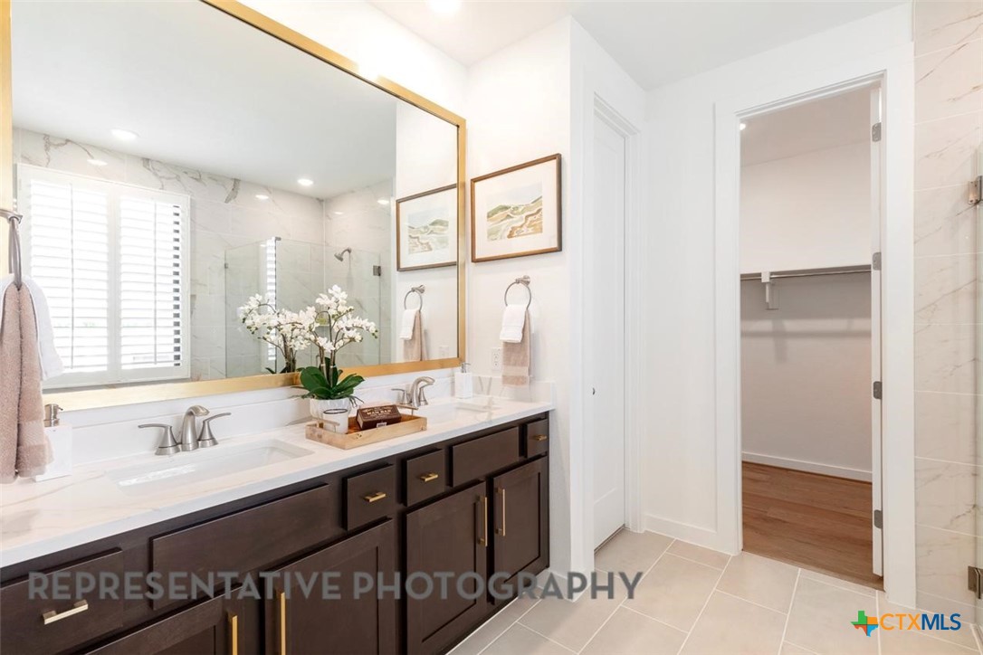 12213 Moon Pool Schertz, TX 78154 - Photo 13 of 32 a bathroom with a granite countertop sink a large mirror and a shower