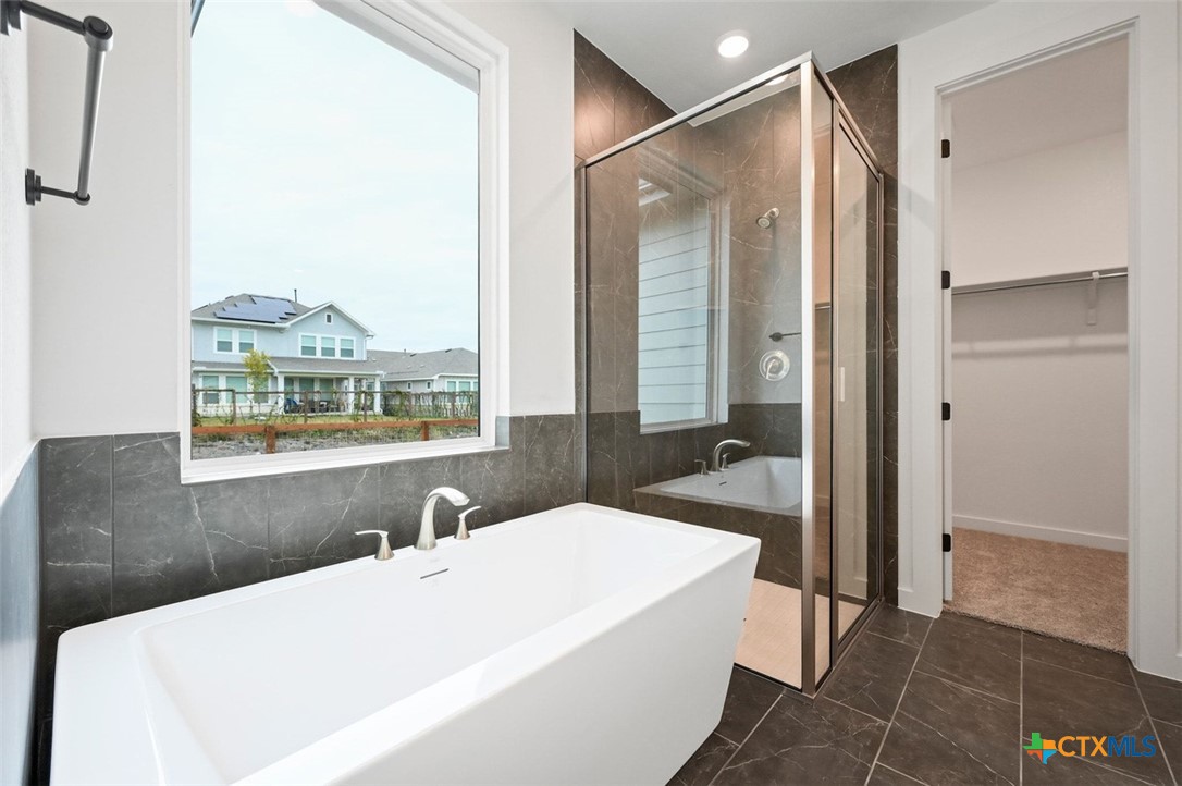 12213 Moon Pool Schertz, TX 78154 - Photo 13 of 25 a en suite bathroom with a tub shower and window