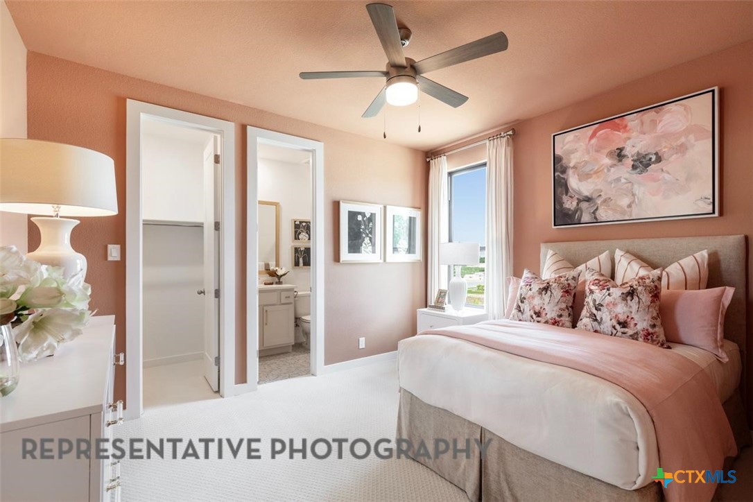 12213 Moon Pool Schertz, TX 78154 - Photo 26 of 32 a bedroom with a large bed and a chandelier