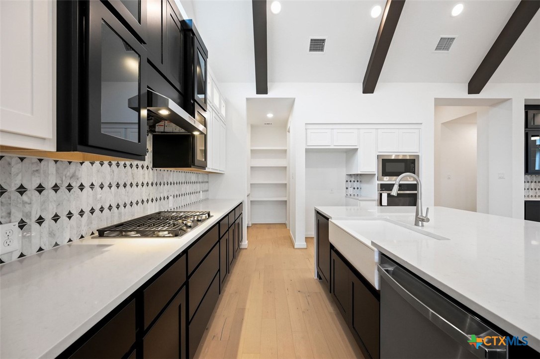 12213 Moon Pool Schertz, TX 78154 - Photo 4 of 25 a kitchen with stainless steel appliances granite countertop a sink and stove